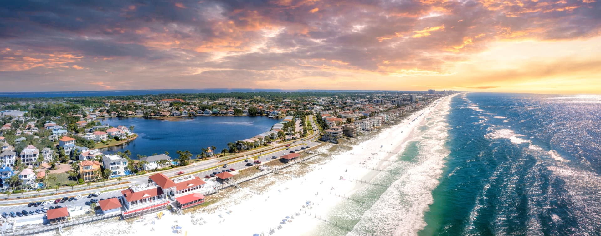 Aerial view of white-sand Gulf beaches, coastal residences and inland water along the Destin and Miramar Beach area of Florida's Emerald Coast