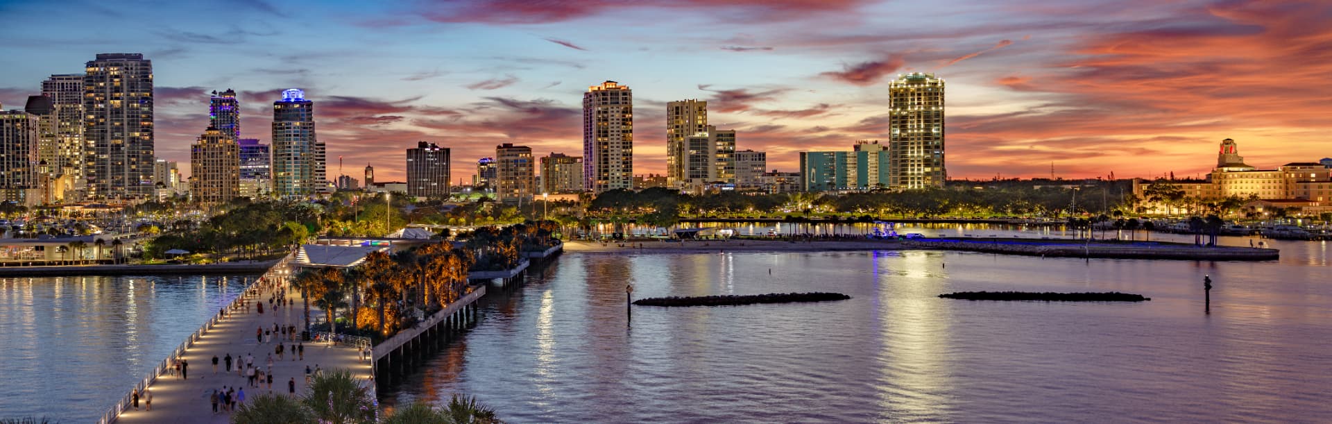 Evening view of the downtown St. Petersburg, Florida skyline and waterfront pier approach at sunset, seen from across the bay